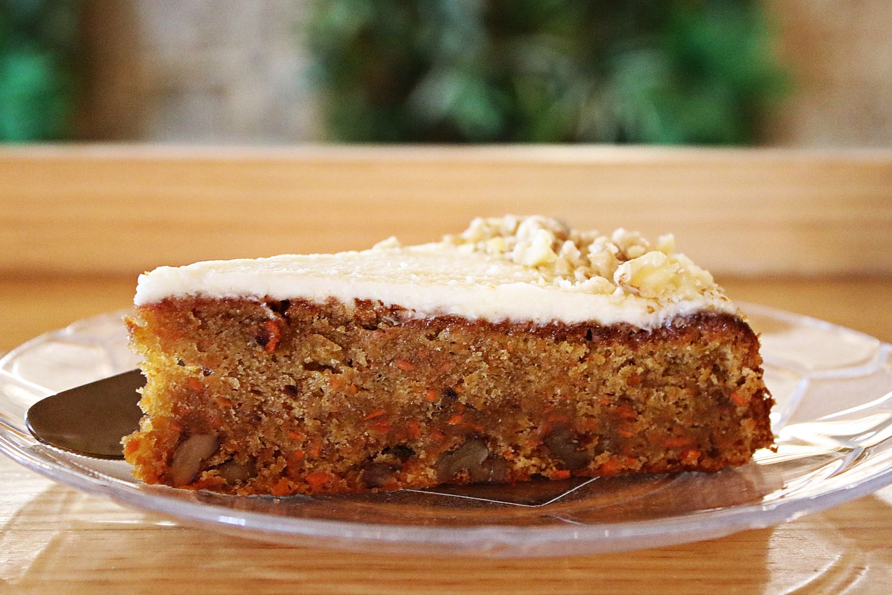 Tranche de carrot cake au glacage cream cheese et noix sur assiette
